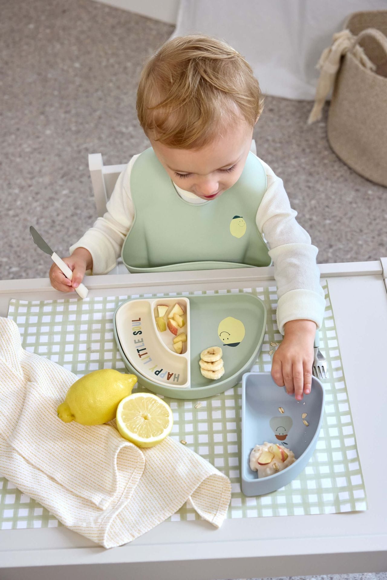 Peuter eet zelfstandig uit de Lässig Happy Fruits Citroen siliconen vakjes bordenset aan tafel