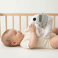 Detail van knuffel olifant met knisperoren en slurf voor kleine handjes. Handgemaakt door Leonietje's. Baby houd knuffel olifant vast in de box
