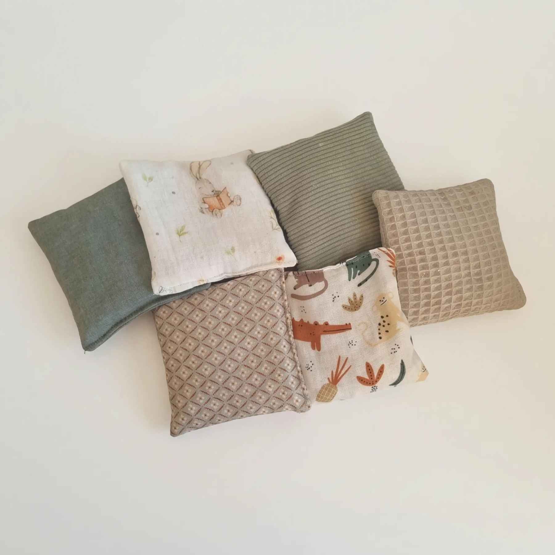 Set van sensorische speelzakjes in vintage groen, gemaakt van zachte stoffen en gevuld met kersenpitten, ideaal voor voelen, grijpen en ontdekken