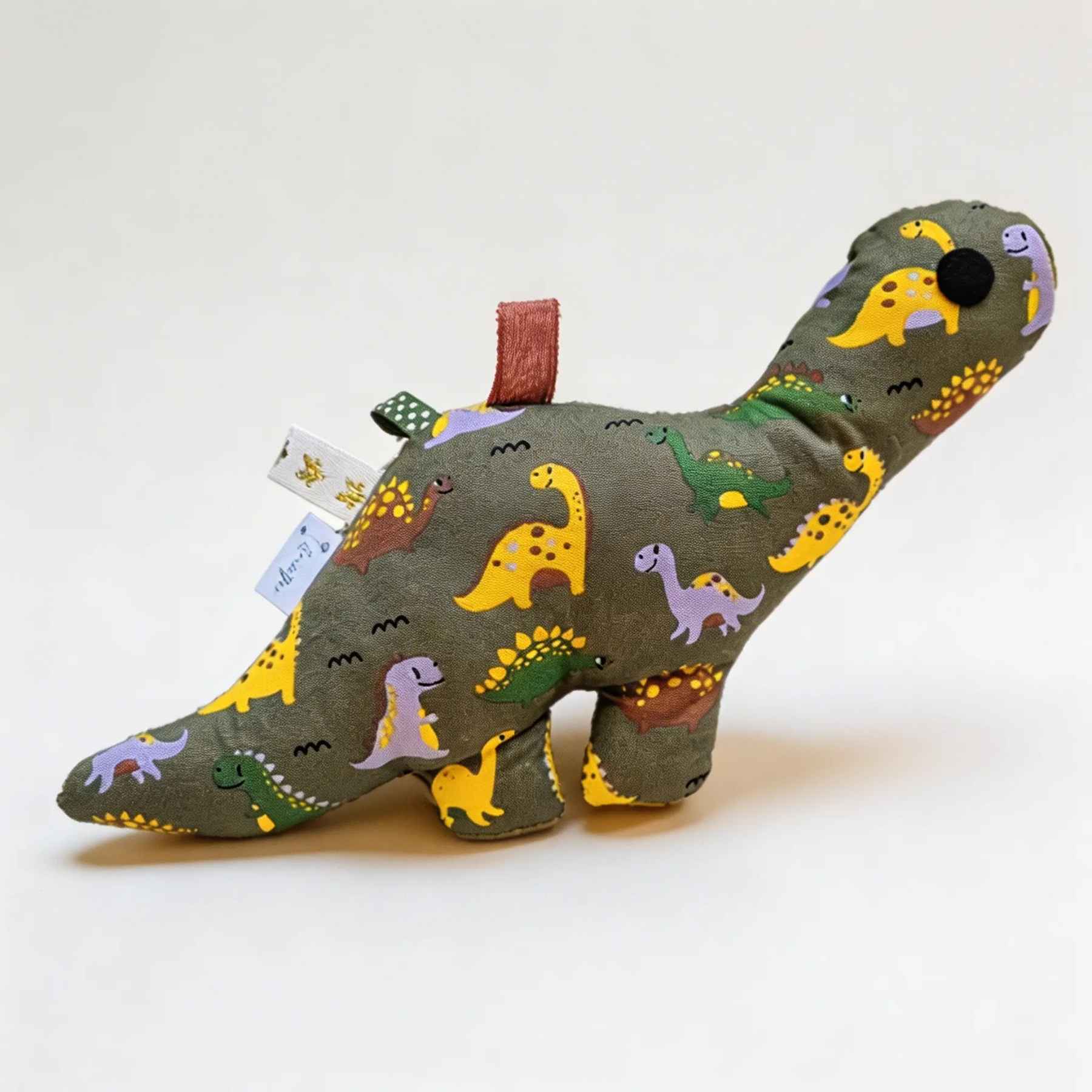 Handgemaakte groene dino knuffel met rammelaar van Leonietje’s