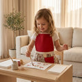 Kinderschortje bordeaux kersenprint rok voorkant, peuter kleuter 2-5 jaar. Handgemaakt door Leonietje's, meisje aan knutselen met een schortje aan. 