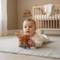 Knisperdoekje Bosdiertjes brick van Leonietje’s met labeltjes en zachte badstof, baby houdt knisperdoekje vast en doet tummytime in de babykamer
